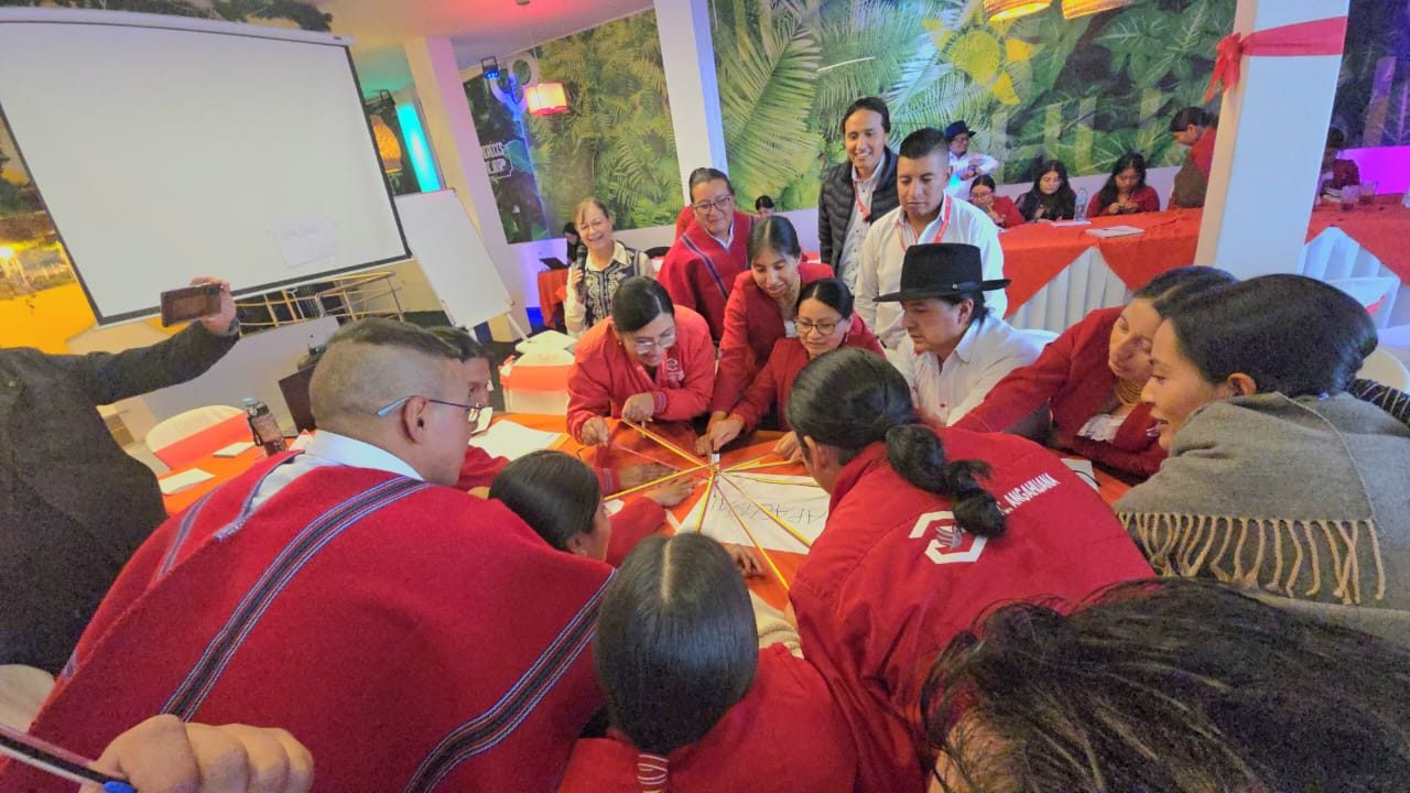 Grupo de participantes trabajando en equipo alrededor de una mesa en un taller de FESPE