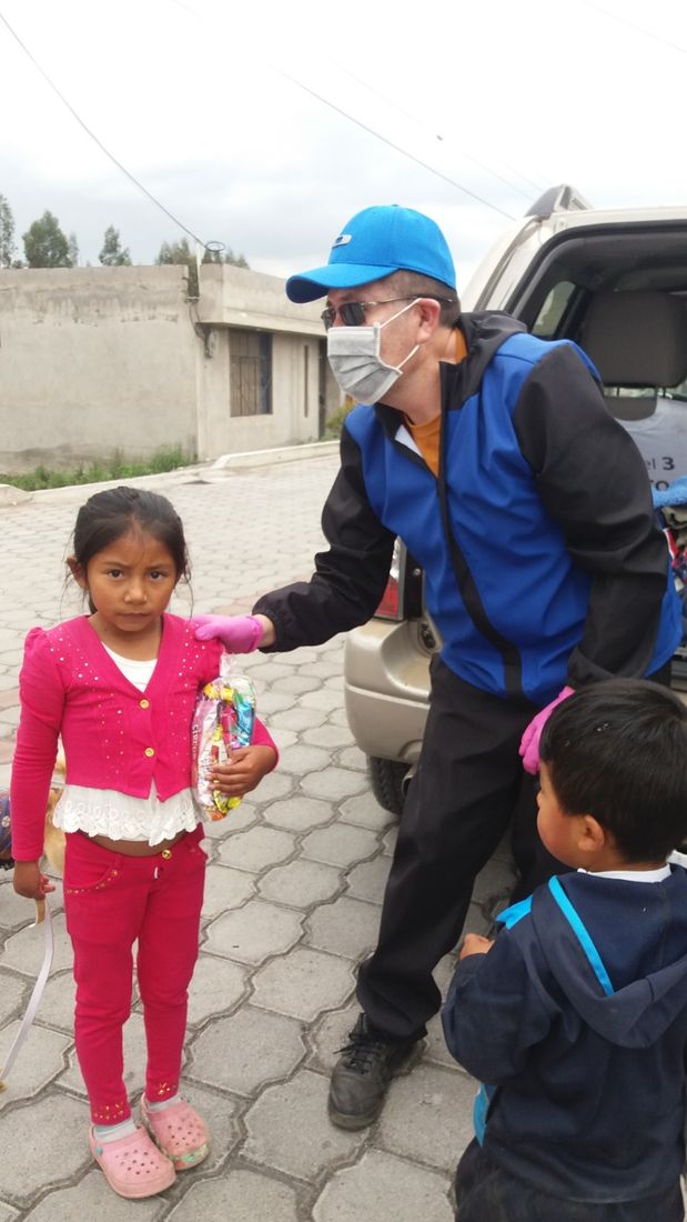 Voluntario entregando un obsequio a una niña de la comunidad